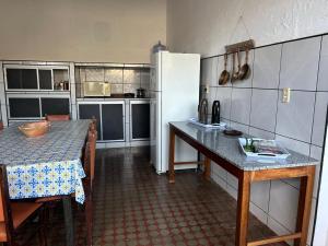 a kitchen with a table and a refrigerator at Casarão no centro de viçosa in Viçosa do Ceará +59 photos