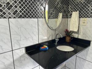 a bathroom with a sink and a mirror at Casarão no centro de viçosa in Viçosa do Ceará