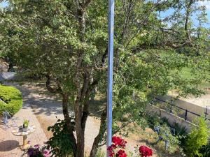 a pole in a garden with a tree and flowers at Chambre in Sorbiers