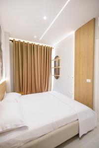 a bedroom with a white bed and a window at Nova Studio Drymades in Dhërmi