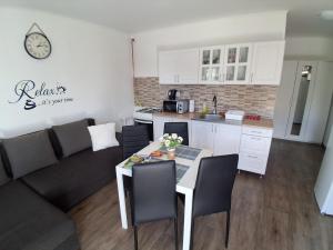 a kitchen and a living room with a table and a couch at GABE Vendègház in Gyöngyöstarján +38 photos