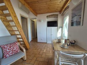 a living room with a wooden table and a chair at Casa Caterina in Marciana Marina