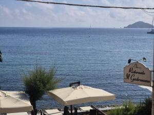 a view of the ocean from a restaurant with umbrellas at Casa Caterina in Marciana Marina