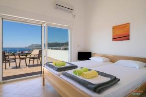 a bedroom with two beds and a view of the ocean at Dubrava Rooms in Dobra Voda