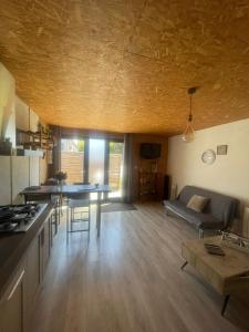 a kitchen and living room with a couch and a table at Petite maison proche Marais Poitevin, Puy dufou in La Ronde