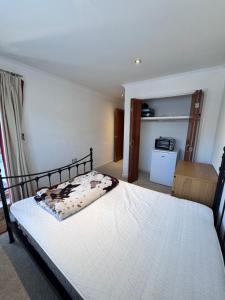 una camera da letto con un letto con una coperta per mucche di Cozy En-suite double room near train station a Reading Altre 3 foto