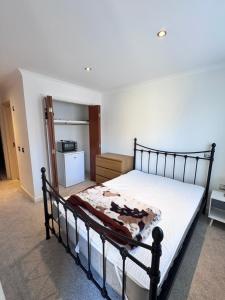 una camera con letto e una cucina con frigorifero di Cozy En-suite double room near train station a Reading
