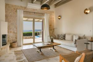 a living room with a couch and a table at Lithos Villas in Vlachata