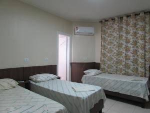 a room with two beds and a window at Las Vegas Hotel in São Paulo