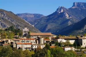 a small town in the mountains with a church at Maison à Die in Die