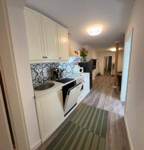 a kitchen with white cabinets and a sink at Apartment A&A in Niederdorf