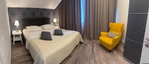 a hotel room with two beds and a yellow chair at Apartment A&A in Niederdorf +54 photos