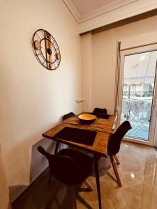 a dining room table with chairs and a clock on the wall at Blue two apartment in Kavála