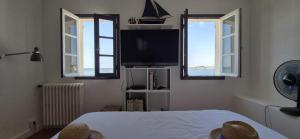 a bedroom with a bed and a flat screen tv at La maison bleue in Bouzigues
