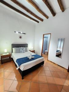 een slaapkamer met een groot bed en een spiegel bij Apartamento de la Villa II in Villa de Leyva