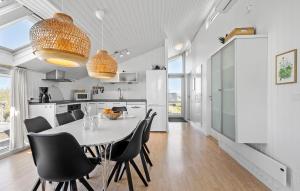 a kitchen and dining room with a table and chairs at Holiday Home Bjerregårdsvej Hvide Sande Ds Denm in Bjerregård