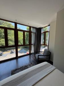 a bedroom with a bed and a chair and windows at Aguas de Ibias in Cecos