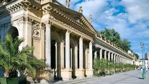 a large building with white columns on a street at Apartment Ondrejska 20 in Karlovy Vary