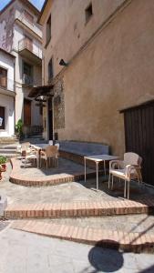 une terrasse avec des tables et des chaises devant un bâtiment dans l'établissement Casa vacanze DA GIOVANNA - Rodio di Pisciotta, à Rodio
