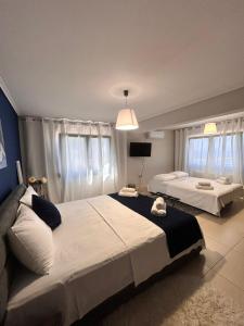 a bedroom with two beds and a tv at Mytilene Luxury Villa Panoramic in Mytilini