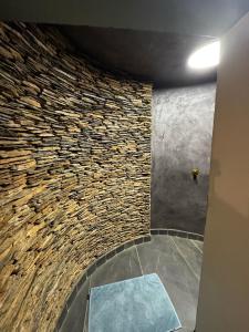 Cette chambre est dotée d'un mur en pierre et d'une table bleue. dans l'établissement AlteVrede Olive Farm, à Doornrivier