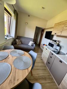 a kitchen and a living room with a table and chairs at Błękitne Wierchy in Murzasichle