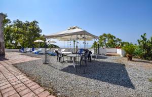 ein Tisch und Stühle unter einem Sonnenschirm auf einer Terrasse in der Unterkunft 2 Bedroom Lovely Apartment In Parghelia in Parghelia + 9 Fotos