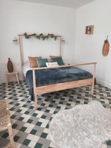 a bedroom with a bed with a wooden frame at Appartement central maison Marceau in Rivesaltes