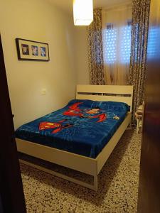 a bedroom with a bed with a blue comforter at Cozy Beachside Apartment in Tavernes de Valldigna +8 photos