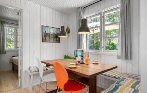 a dining room with a wooden table and chairs at 4 Bedroom Lovely Home In Mern in Mern