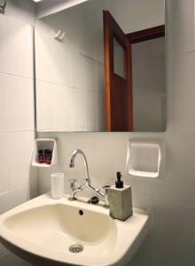 a white sink in a bathroom with a mirror at Skala Eresos Paradise Studios in Skala Eresou +15 photos