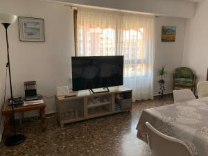 a living room with a flat screen tv on a cabinet at Plaza Mare Nostrum 5 min playa in Puerto de Sagunto
