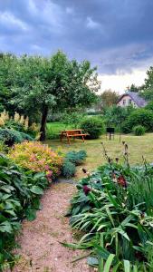 a garden with a picnic table and some flowers at Ciemos pie Ingas in Smiltene