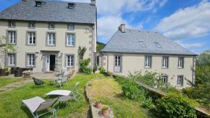 a large white building with chairs and tables in front of it at DATCHA ANASTASIA in Besse-et-Saint-Anastaise