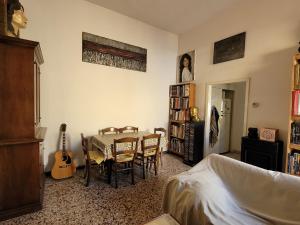 a living room with a table and chairs and a guitar at Ampia camera vicina al centro in Florence