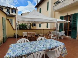 a patio with tables and chairs and a white umbrella at Ampia camera vicina al centro in Florence