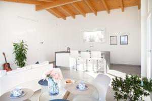 a white living room with a table and chairs at Casa Vacanza Santa Lucia in Spoltore