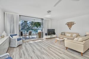 a living room with a couch and a tv at Paringa Beachfront Apartment 7 with Ocean Views in Palm Cove