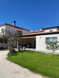 a white house with a green yard in front of it at Casa Vacanza Santa Lucia in Spoltore