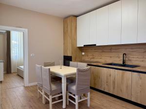 a kitchen with a table and chairs and a sink at Guest House Deon in Vlorë