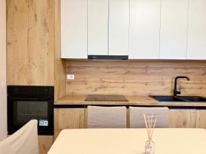 a kitchen with white cabinets and a table with a sink at Guest House Deon in Vlorë +103 photos