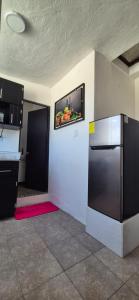 a kitchen with a refrigerator and a tv on the wall at Deptos Lago de Guadalupe in Mexico City +9 photos