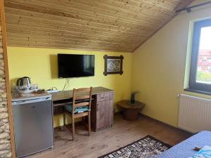 Una habitación con un escritorio y un televisor en la pared. en Casa Adelmar, en Tulcea