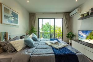 Un dormitorio con una cama grande con una ventana grande. en C123 Rawai Beachfront Vibe 1BR Chill & Swim Spot, en Rawai Beach 20 fotos más