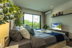 Un dormitorio con una cama grande y una ventana grande. en C123 Rawai Beachfront Vibe 1BR Chill & Swim Spot, en Rawai Beach
