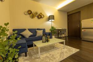 Una sala de estar con un sofá azul y una mesa. en C123 Rawai Beachfront Vibe 1BR Chill & Swim Spot, en Rawai Beach