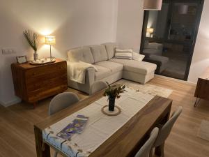 a living room with a table and a couch at Gandia Playa Moderna - nuevo con piscina y parking, 2 banos, playa 300 m, grau 300 m in Playa de Gandia