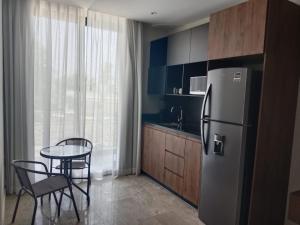 a kitchen with a refrigerator and a table with chairs at Turix 102 in Puerto Morelos