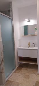 a white bathroom with a sink and a mirror at Cottages Occitans in Villepinte +37 photos