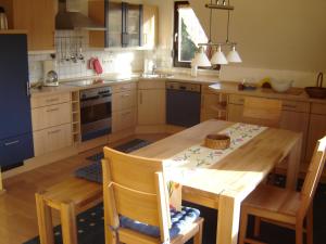 une cuisine avec une table en bois et une table et des chaises dans l'établissement Ferienwohnung Friedmann, à Memmelsdorf 4 autres photos